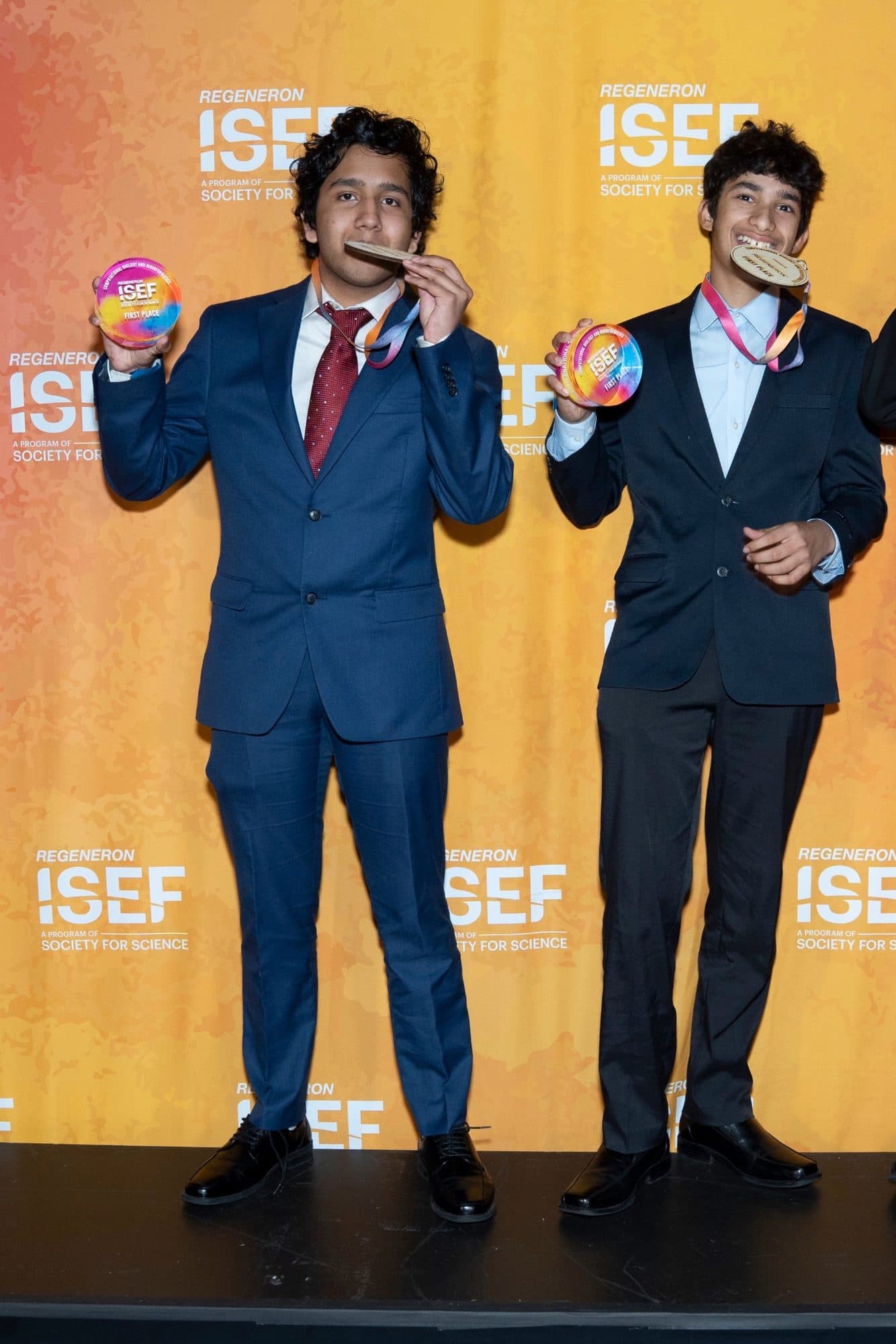 Aryav Das and Samarth Dunakhe holding their first place medals and Regeneron ISEF trophies at the awards ceremony