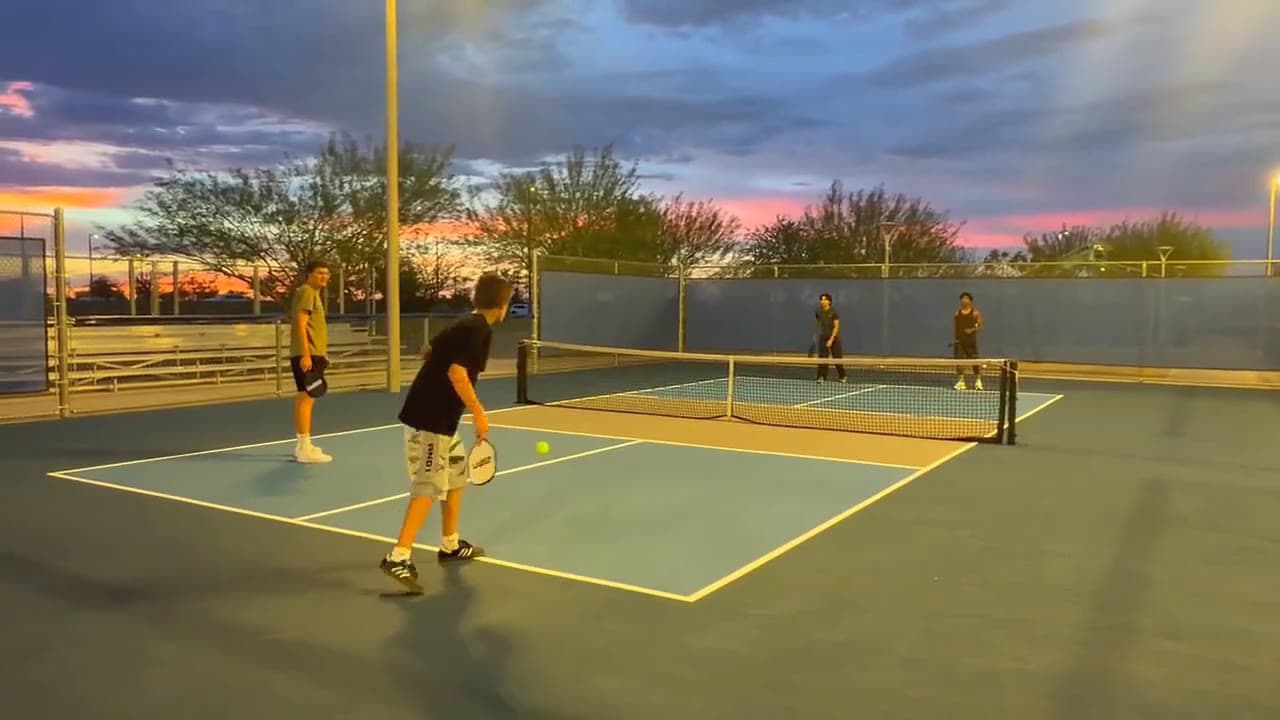 Players on the pickleball courts at Gilbert Regional Park under a pink and purple sunset sky